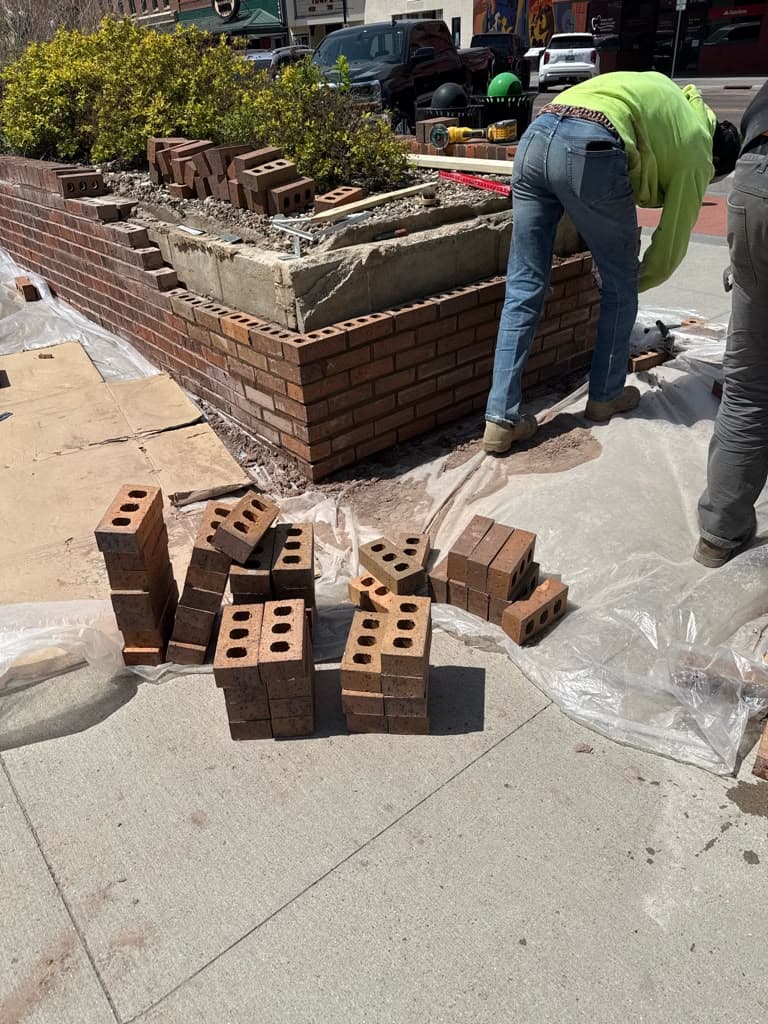 Brick planter construction in progress on a downtown sidewalk