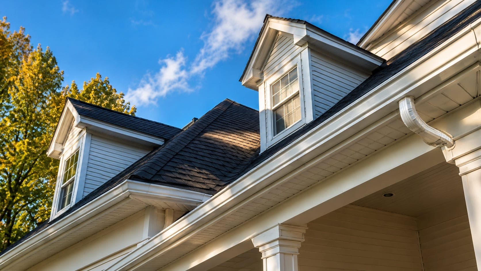 Roofline with dormer windows, shingles and gutters on a residential home